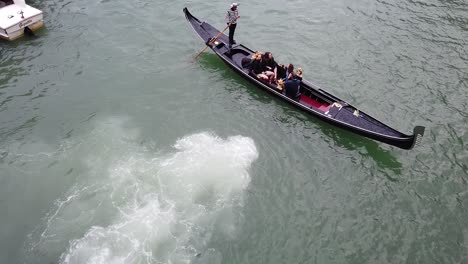 people-in-gondola-italy-traditional-small-boat,-high-angle-tracking-shot