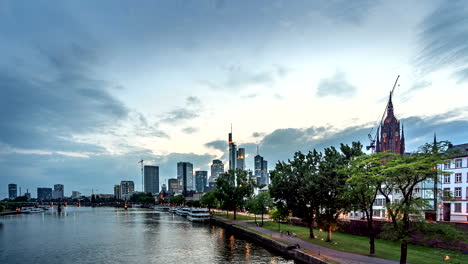 Zeitraffer-Der-Blick-Vom-Main-Auf-Die-Skyline-Der-Stadt-Frankfurt-Bei-Sonnenuntergang,-Hessen,-Deutschland,-Juli-2018