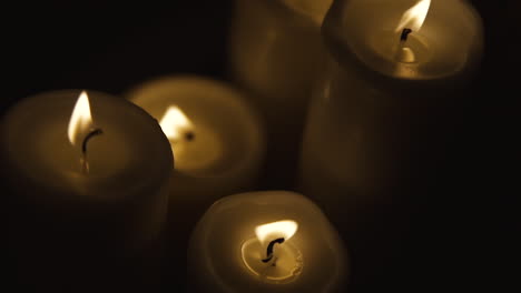 Group-of-four-candles-on-fire,-shot-top-of-fire,-slow-motion-footage