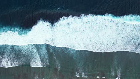 Sea-waves-texture-seen-from-above-showing-energy-of-ocean-by-big-waves-splashing-on-shallow-lagoon-with-rocks-and-coral-reefs-in-Australia