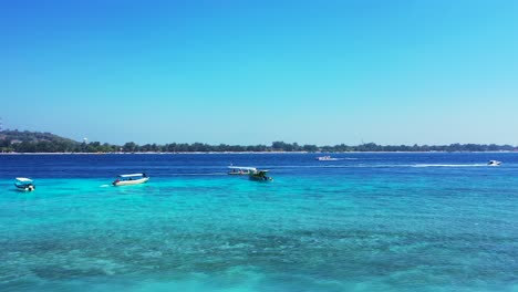 Maldives-Island-Beach-Showing-Boats-Sailing-Across-The-Bright-Blue-Deep-Ocean---Wide-Shot