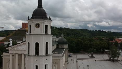 Aerial-shot-moving-laterally-showing-the-tower-of-Vilna´s-Cathedral,-with-the-ediminas-tower-at-the-background