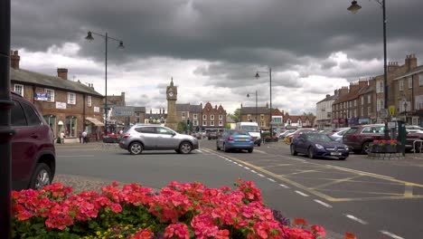 Thirsk,-North-Yorkshire---slow-moving-traffic-and-people-walking-about-in-the-Market-place