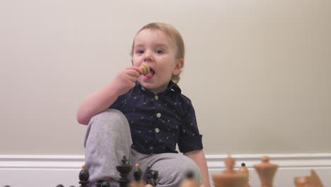 Curious-toddler-boy-puts-a-chess-piece-in-his-mouth