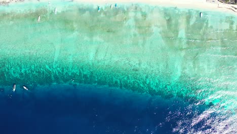 Kleine-Boote-Segeln-Um-Das-Ruhige,-Klare,-Glänzende-Wasser-Der-Blau-türkisfarbenen-Lagune-Nahe-Der-Küste-Einer-Tropischen-Insel-In-Der-Karibik