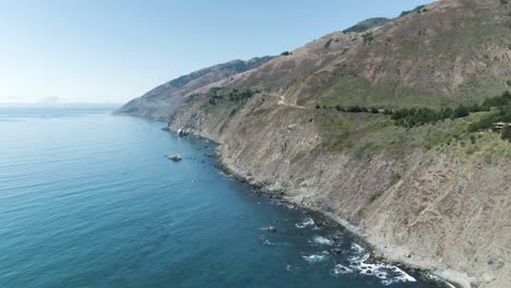 Slowly-rising-aerial-of-the-Pacific-Ocean-coastline-highway,-Highway-1,-in-California,-USA