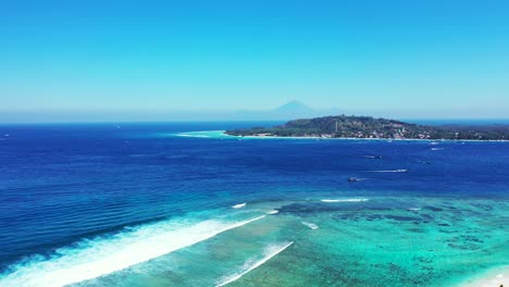 Beautiful-seaside-with-boats-sailing-on-blue-sea-and-turquoise-lagoon-around-shore-of-tropical-islands-washed-by-white-waves,-Indonesia