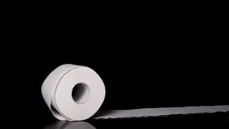 Toilet-Paper-Roll-Rolling-Across-Screen,-Slow-Motion-Black-Background