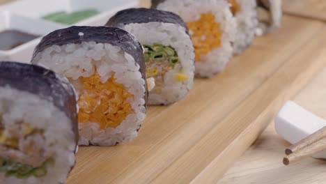 Slider-Dolly-Shot-of-Sushi-on-a-Wooden-Sering-Platter-with-Chopsticks