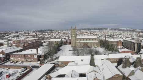 Aerial-view-of-St-Jame's-church-covered-in-snow-in-the-midlands,-Christian,-Roman-catholic-religious-orthodox-building-in-a-mainly-muslim-area-of-Stoke-on-Trent-in-Staffordshire,-City-of-Culture