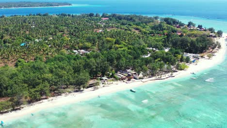 Tranquil-exotic-beach-of-tropical-island-full-of-palm-trees-and-bar-restaurants,-surrounded-by-shallow-turquoise-lagoon-in-Gili-Meno,Indonesia