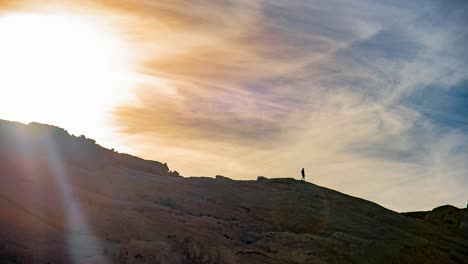 Beautiful-cinemagraph-of-a-hiker-walking-down-a-mountain-ridge-at-sunset