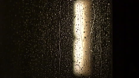 Raindrops-on-the-window-on-a-dark-rainy-day---closeup-shot