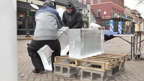 Ice-sculptors-loading-ice-block-on-dolly-with-ice-tongs