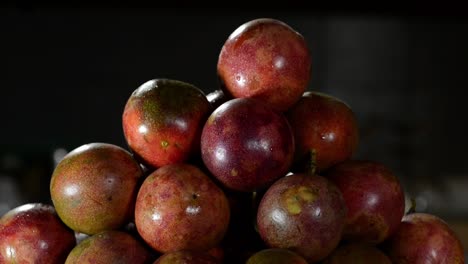 Tiltt-up-shot-of-Many-passion-fruits-in-focus-on-table,close-up-in-studio