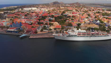 Cruise-line-aerial-footage-of-a-ship-docked-in-the-Dutch-Caribbean-port-of-Willemstad,-Curacao