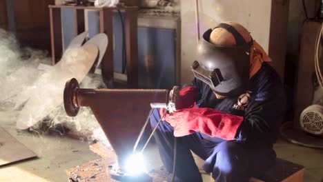 A-welder-at-a-foundry-welding-metal-with-face-protective-mask-on