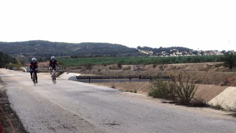 Cyclist-taking-daily-exercise-along-road-running-next-to-aqueduct-in-Spain