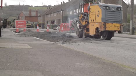 Heavy-plant-tarmac-machinery-and-road-cones-on-closed-road-wide-low-shot