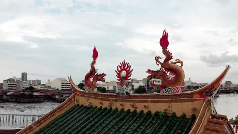 Roof-detail-of-Kuan-Yin-Floating-Buddhist-Temple-located-in-the-Jetty-area-of-the-old-city,-Aerial-orbit-around-reveal-shot