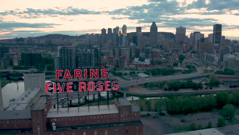 Aerial-shot-of-the-glowing-Farine-Five-Roses-sign-moving-up-and-showing-Montreal-'s-downtown-skyline