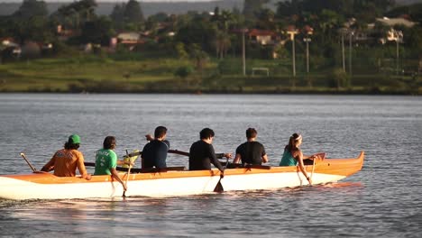 Colourful-rowing-team-crew-practising-in-harmony-in-orange-canoe-boat