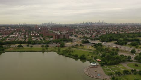 an-aerial-view-over-a-park's-pond-on-a-gray-and-cloudy-day