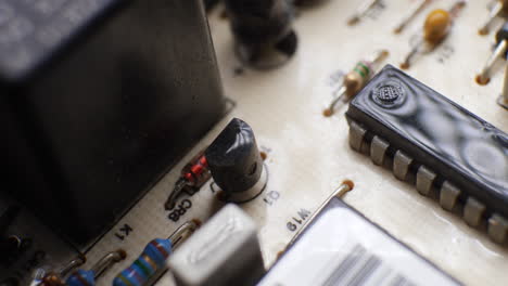 Un-Transistor-Y-Un-Chip-De-Circuito-Integrado-Ic-En-Una-Placa-Antigua-Polvorienta-Con-Muchos-Otros-Componentes-Electrónicos