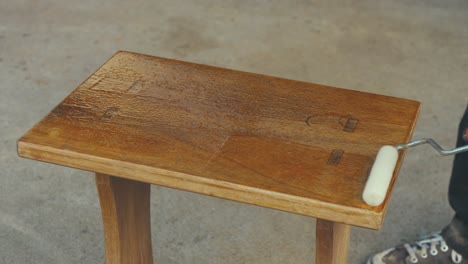Varnishing-small-wooden-oak-table-with-roller,-Timelapse