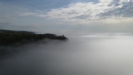 Split-rock-light-house-during-a-foggy-sunny-morning,-aerial-footage