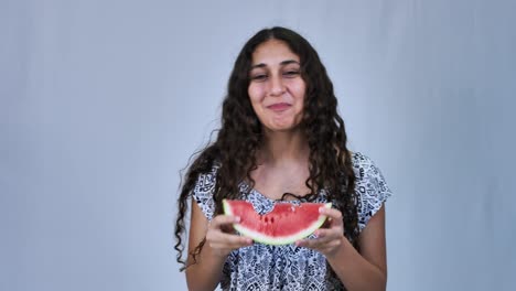 Happy-teenage-girl-with-long-curly-hair-eating-watermelon,-white-background