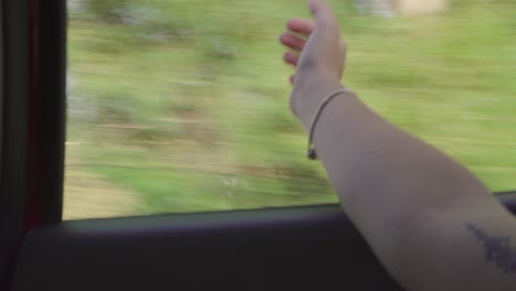 View-Of-Female-Arm-Catching-Wind-From-Window-Of-Moving-Car