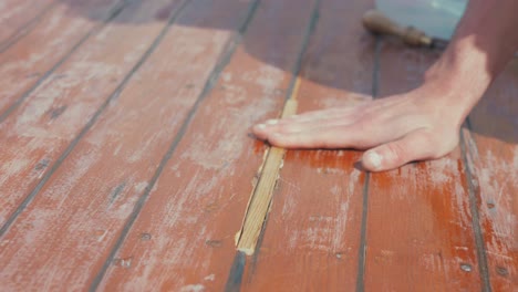 Fitting-wooden-spline-insert-into-wooden-boat-roof-planking-rubbing-hand-across