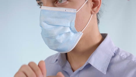 Extreme-Closeup-of-Man-Putting-on-Disposable-Face-Mask