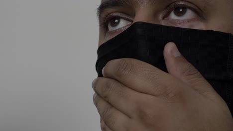 Adult-UK-Asian-Male-Wearing-Balaclava-Indoors-With-Hand-Placed-On-Mouth