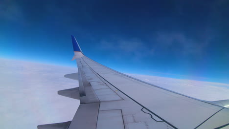 Feine-Wolken-Schweben-Direkt-über-Der-Tragfläche-An-Den-Fenstern-Eines-Flugzeugs-Vorbei