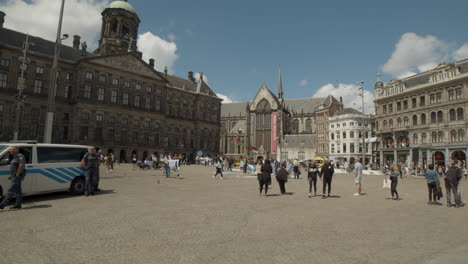 People-walking-over-the-historical-Dam-square-in-Amsterdam-in-the-summer