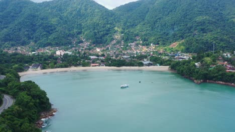 Aerial:-drone-shot-in-brazil-santa-rita-beach-ubatuba-with-view-to-yacht-park-sailboats-in-on-the-road-that-passes-the-sea-and-the-jungle-sunset-sao-paulo-san-pablo-litoral-north-escuna-lancha