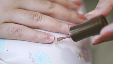 Closeup-of-a-woman-paints-her-nails-by-self-made-manicure-at-home-slow-motion-scene