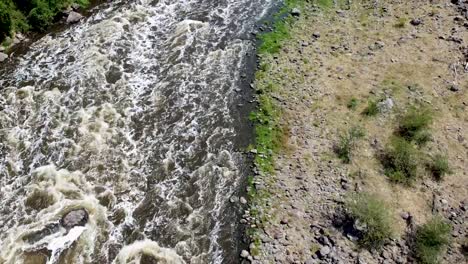 Aerial-drone-tilting-up-from-a-rapid-river-in-a-canyon-in-Mexico