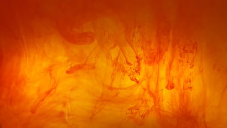 Ink-swirls-creating-a-fire-burning-effect-with-orange-and-red-dye-moving-in-the-water,-beautiful-background-color-footage