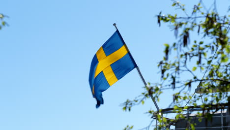 Bandera-De-Suecia-Volando-Contra-El-Cielo-Azul