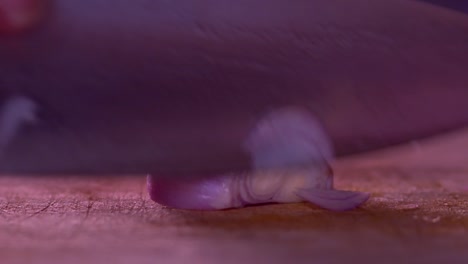 Close-up-video-of-the-hands-of-a-man-cutting-thin-slices-of-onion-on-a-chopping-board