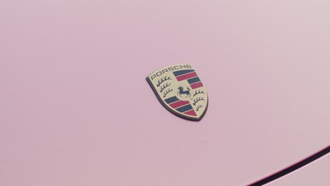 Zoom-out-on-a-Porsche-logo-on-top-of-pink-color-hood