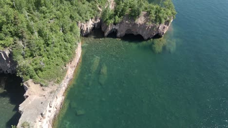 Aerial-view-of-sea-caves-and-rock-formations-at-Lake-Superior-shoreline-in-Minnesota-during-summer