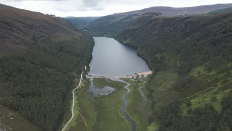 Scenic-View-Of-Glendalough-Upper-Lake-Surrounded-By-The-Lush-Green-Forest-And-Mountains-In-County-Wicklow,-Ireland