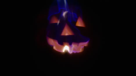 Slow-motion-medium-shot-of-a-jack-o-lantern-on-fire-as-flames-flicker-and-dance-across-its-face
