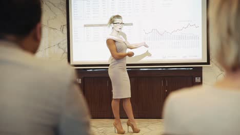Geschäftsfrau-Diskutiert-Datenanalyse-In-Einer-Geschäftspräsentation-Mit-Diagrammen-Und-Informationen-Auf-Einer-Großen-Projektorleinwand-–-Totalaufnahme,-Zeitlupe