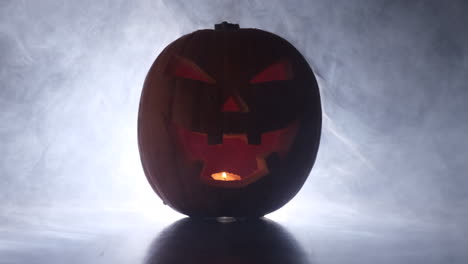 Halloween-glowing-pumpkin-face-in-dark-smoke-fog