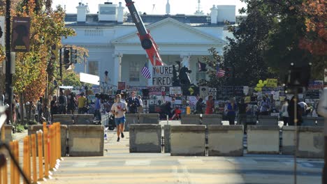 Protest-signs-opposing-President-Donald-Trump-are-seen-on-a-security-barrier-around-the-White-House-in-Washington,-DC-following-the-November-3rd,-2020-U